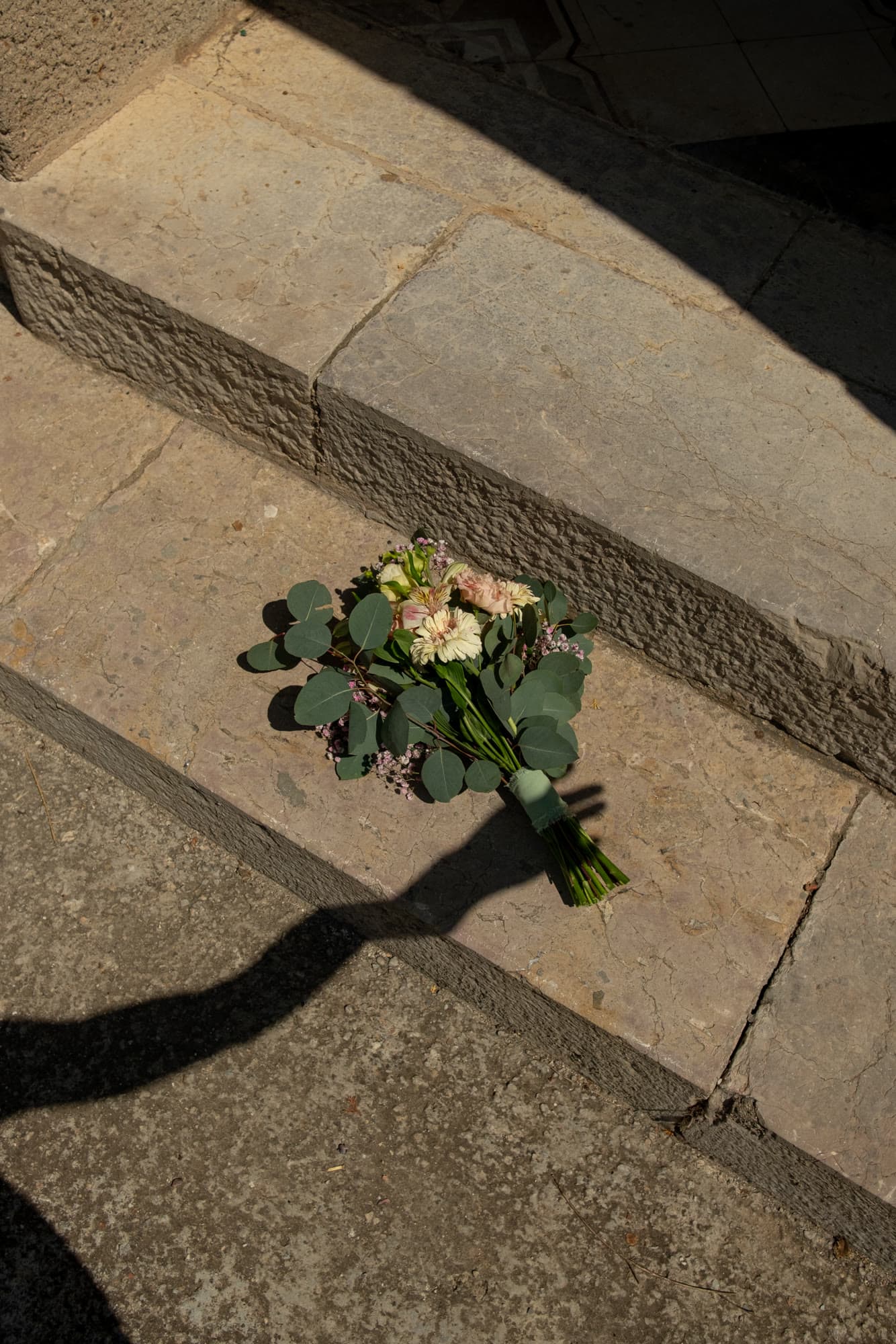 Bouquet resting on sunlit stone steps